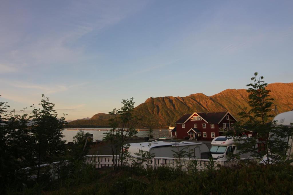 a group of boats parked in front of a house at Toftenes Sjøhuscamping AS in Alsvåg