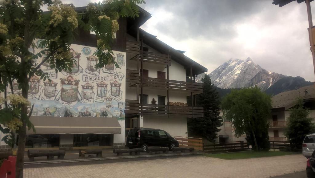 a building with a van parked in front of it at Appartamenti Bernard Sas in Canazei