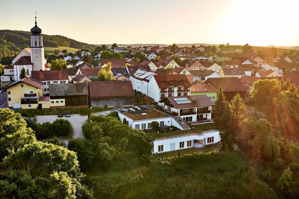 a small town with a church and a town with houses at Zedernhof Gesundheits- & Wellnesshotel in Stamsried