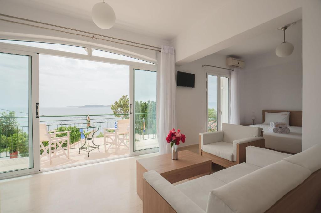 a living room with white furniture and a large window at Studios Angeliki in Lassi