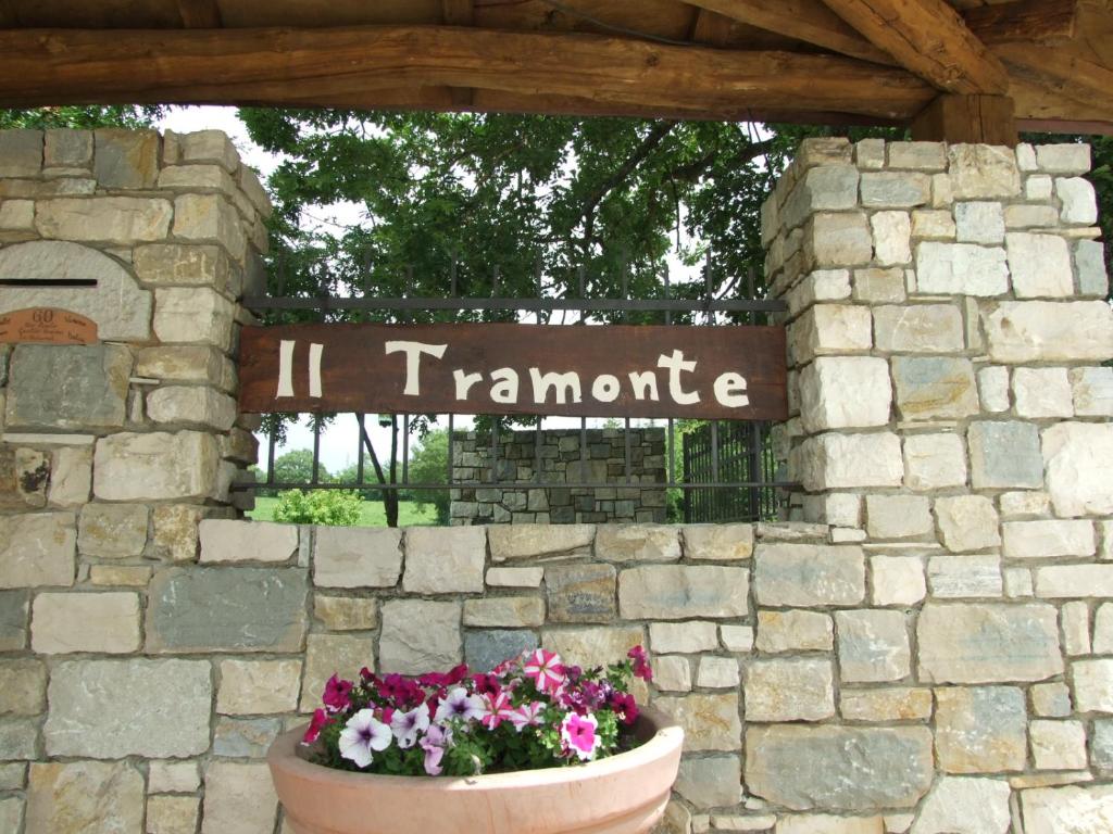 a sign in a stone wall with flowers in a pot at Il tramonte in Vinchiaturo