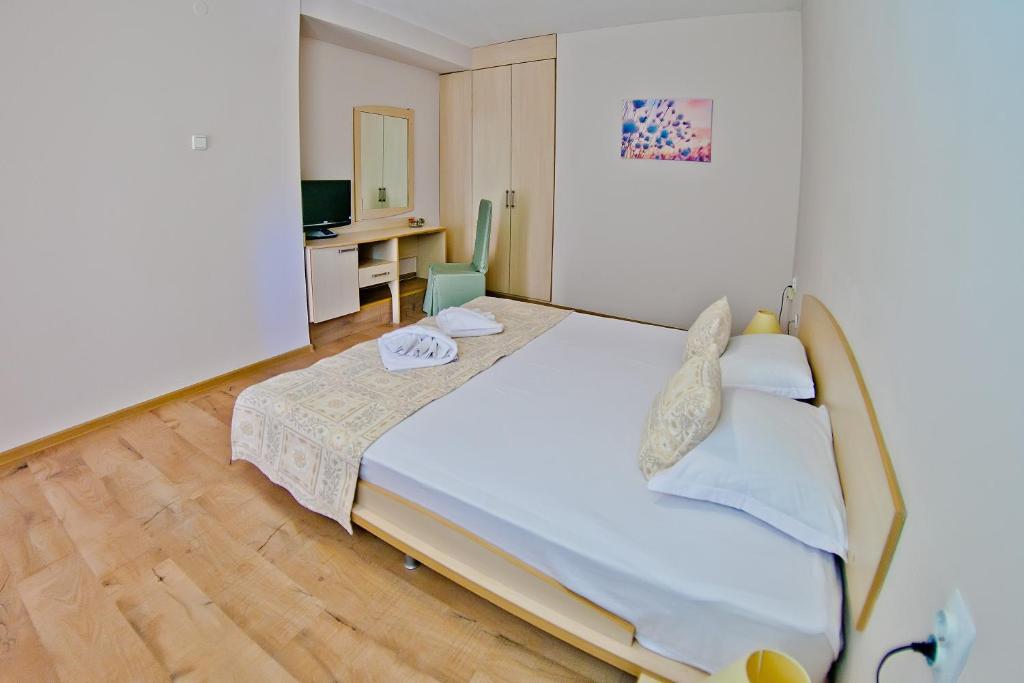 Schlafzimmer mit einem großen Bett und einem Schreibtisch in der Unterkunft Hotel Amfora in Sweti Konstantin