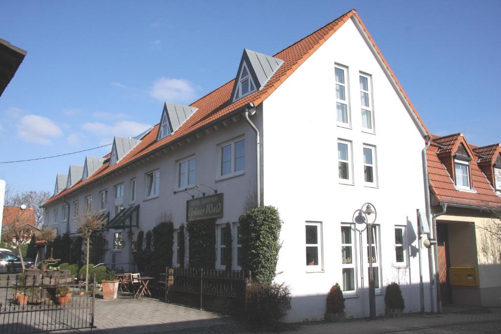 ein weißes Gebäude mit rotem Dach auf einer Straße in der Unterkunft Hotel Gasthof Grüner Wald in Hofheim am Taunus