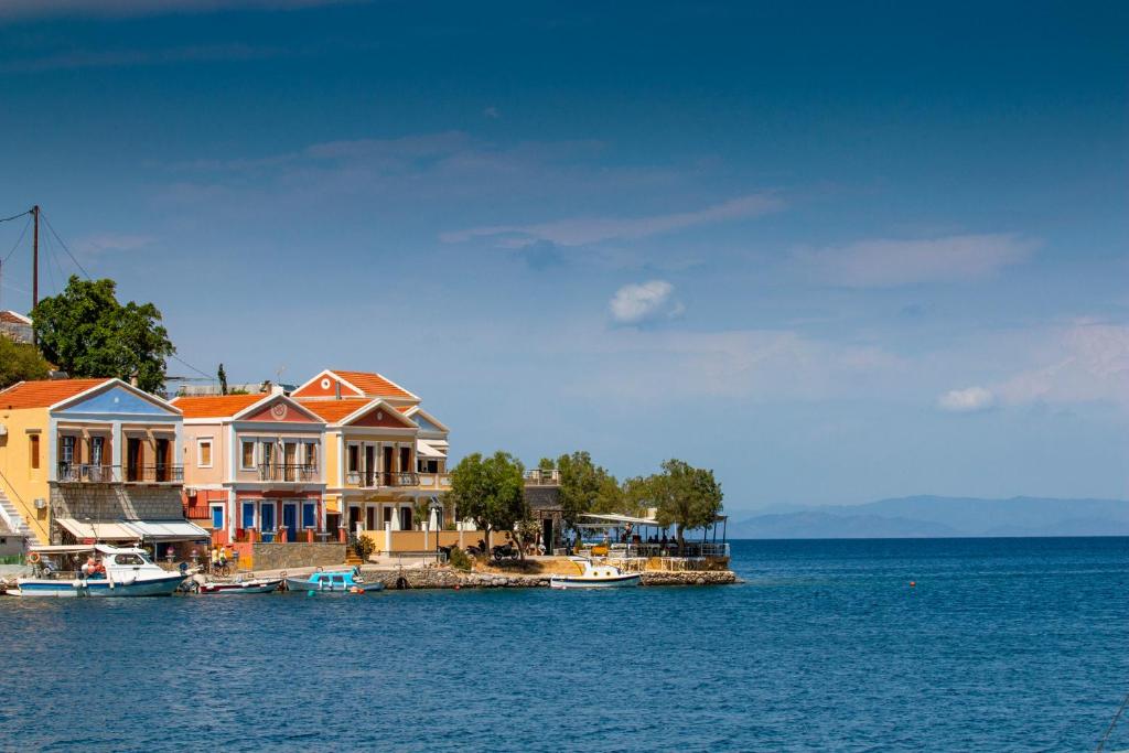 um grupo de casas numa doca na água em Villa Galanis em Simi