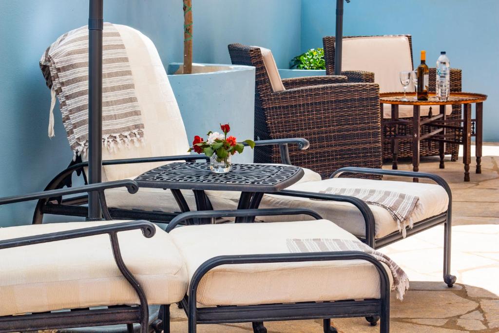 a patio with chairs and a table with a vase of flowers at Villa Galanis in Symi