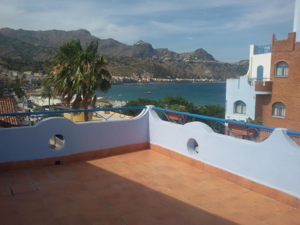 a balcony with a view of the ocean and mountains at Villa Athena in Giardini Naxos