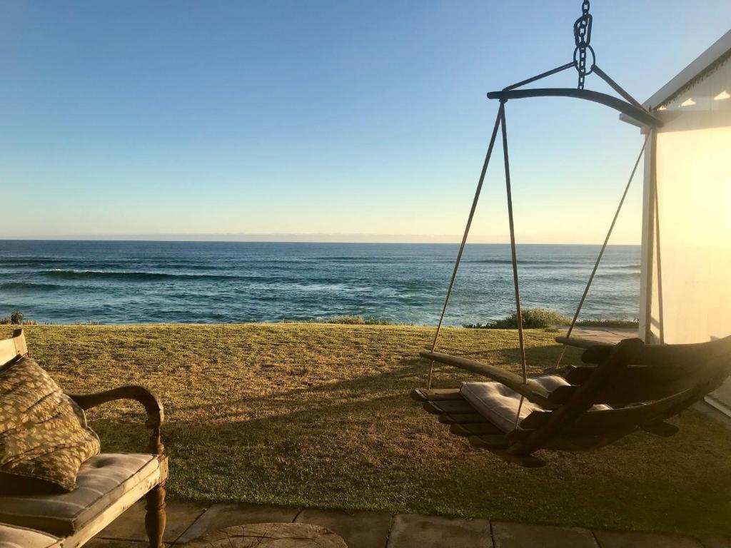 eine Schaukel mit dem Ozean im Hintergrund in der Unterkunft The Beach House - Glentana in Glentana