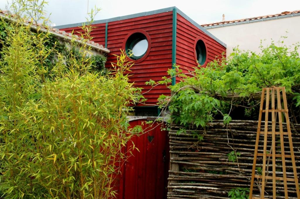 una casa roja con una ventana a un lado. en Maison du chat bleu en Saint-Hilaire-de-Clisson