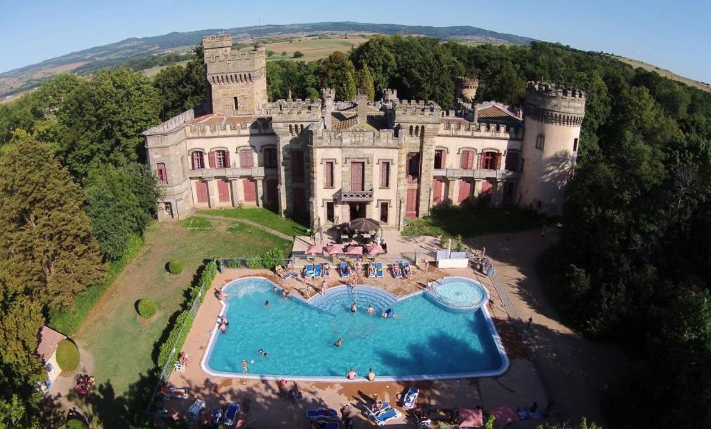 un castillo con piscina frente a él en Chateau-camping la Grange Fort, 63500 Les Pradeaux, en Les Pradeaux