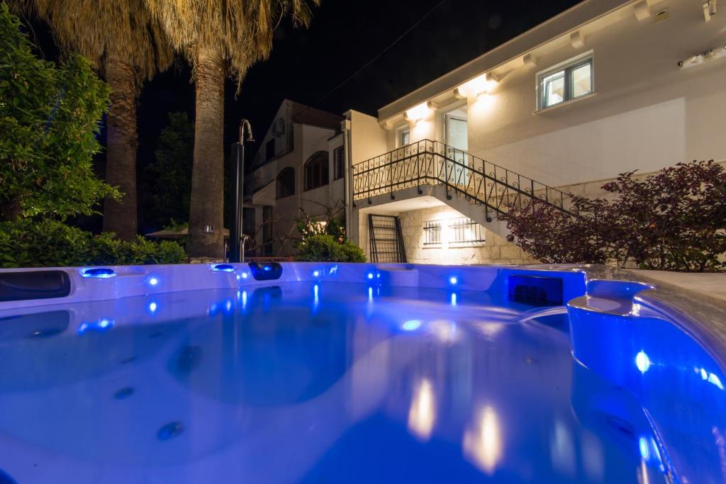 a swimming pool in front of a house at night at Villa Hurem in Trogir