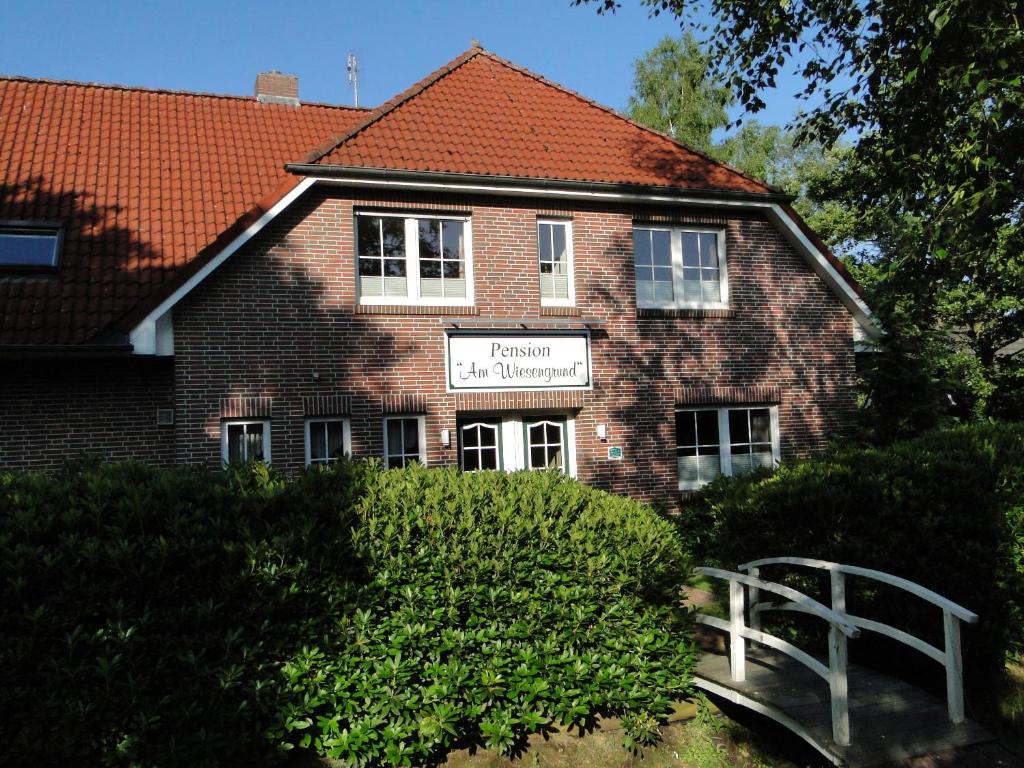 a brick building with a sign in front of it at Pension Am Wiesengrund in Detern