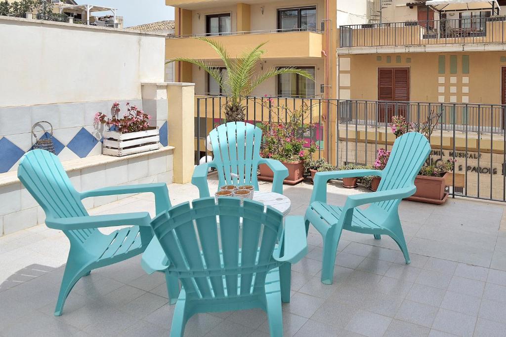 three chairs and a table on a patio at Terrazza sul Corso in Pozzallo