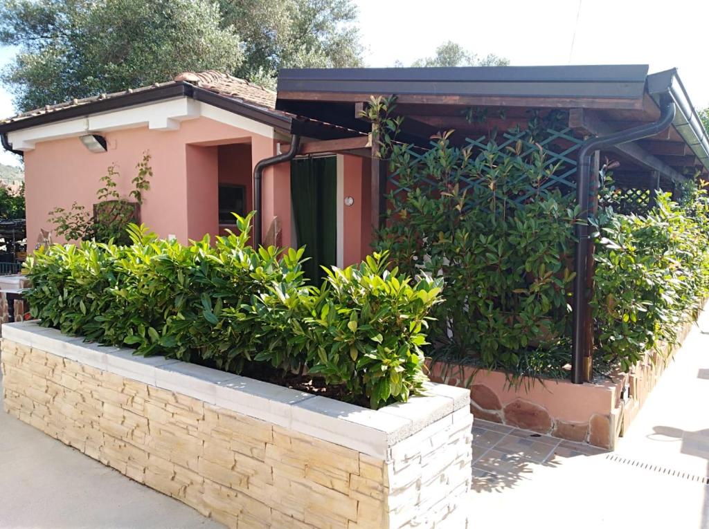 a small house with a brick wall and bushes at Casa Vacanze Mimose in Palinuro