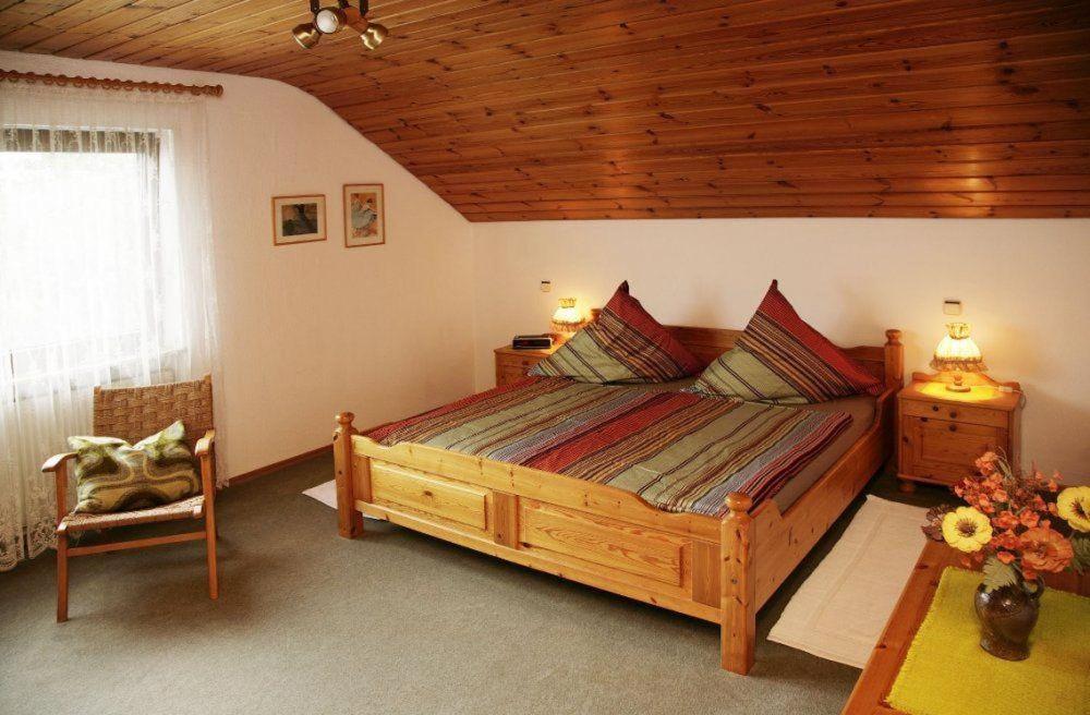 BermatingenにあるHaus-Voelkerの木製の天井が特徴のベッドルーム1室(大型ベッド1台付)