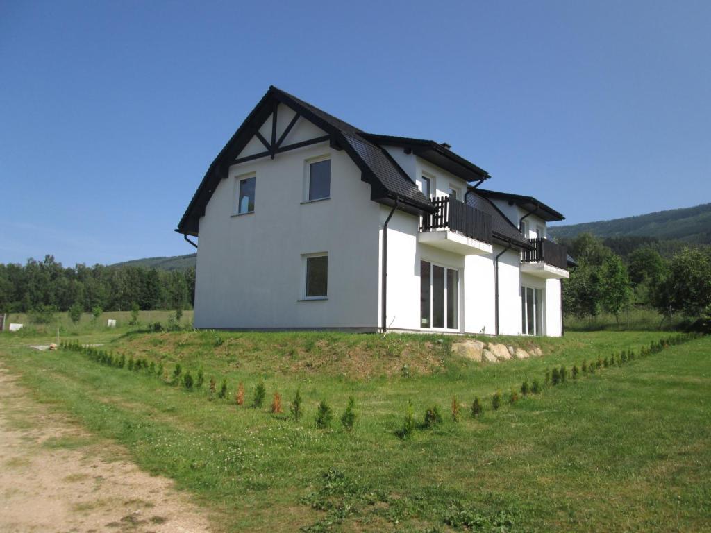 a white house on top of a grassy hill at Eol in Karpacz