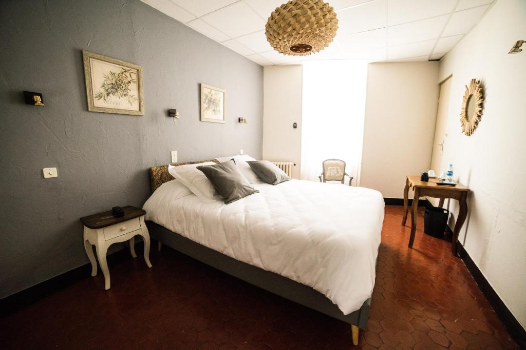 Logis hôtel restaurant de Provence في أورانج: غرفة نوم بسرير كبير مع شراشف بيضاء