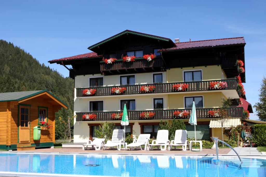 a hotel with a swimming pool in front of a building at Timmelbauerhof in Ramsau am Dachstein