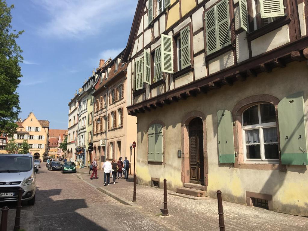 Un groupe de personnes marchant dans une rue à côté des bâtiments dans l'établissement Le Bratzala, à Colmar