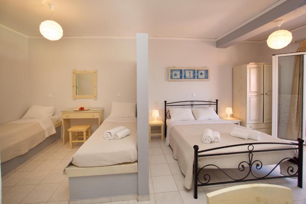 a hotel room with two beds and a bathroom at Minas Apartments in Divarata