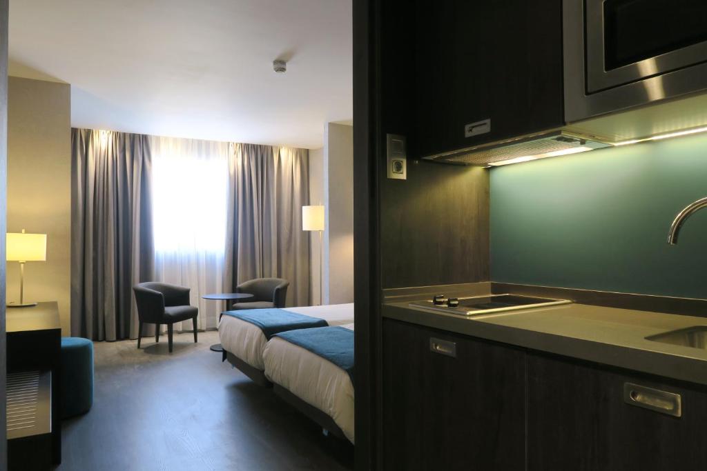 a hotel room with a bed and a sink at Hg City Suites Barcelona Apartments in Barcelona
