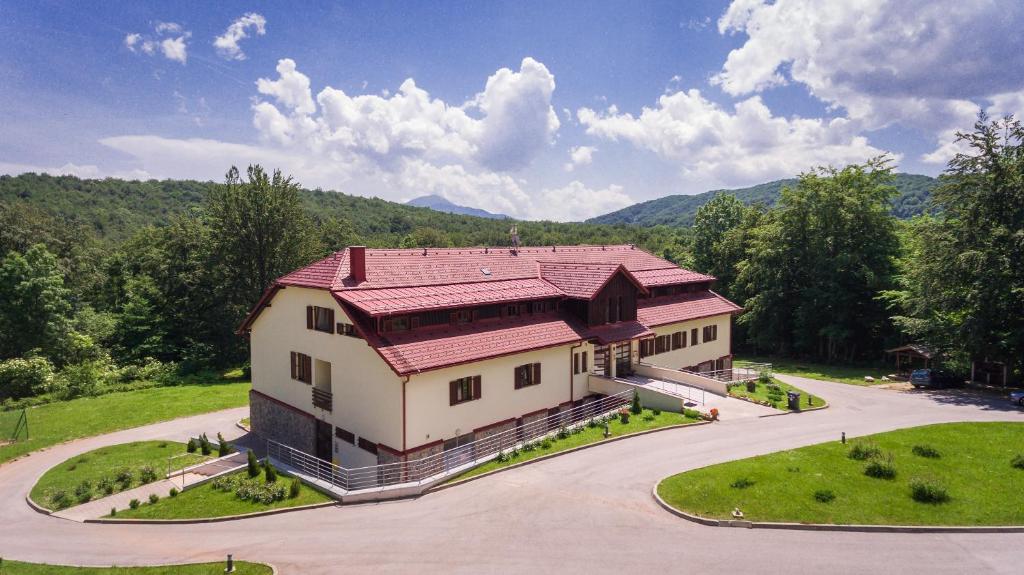 widok z góry na dom z czerwonym dachem w obiekcie Guest House Plitvicki Emaus w mieście Jeziora Plitwickie