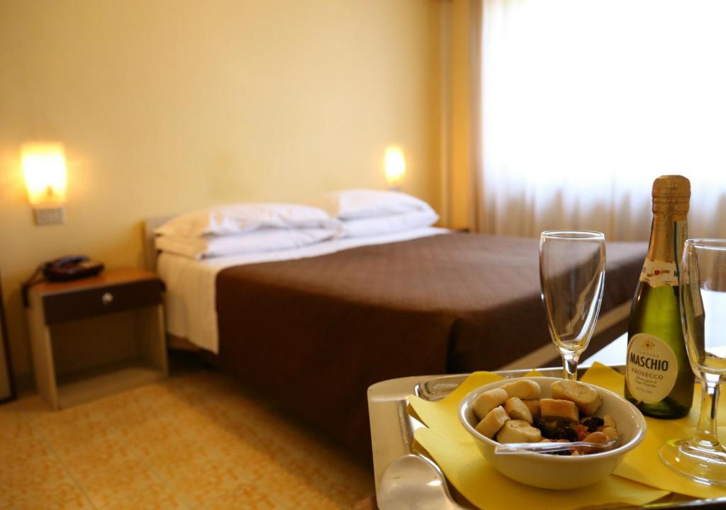 a hotel room with a bed and a table with a bowl of food at Hotel Sole in Nocera Inferiore