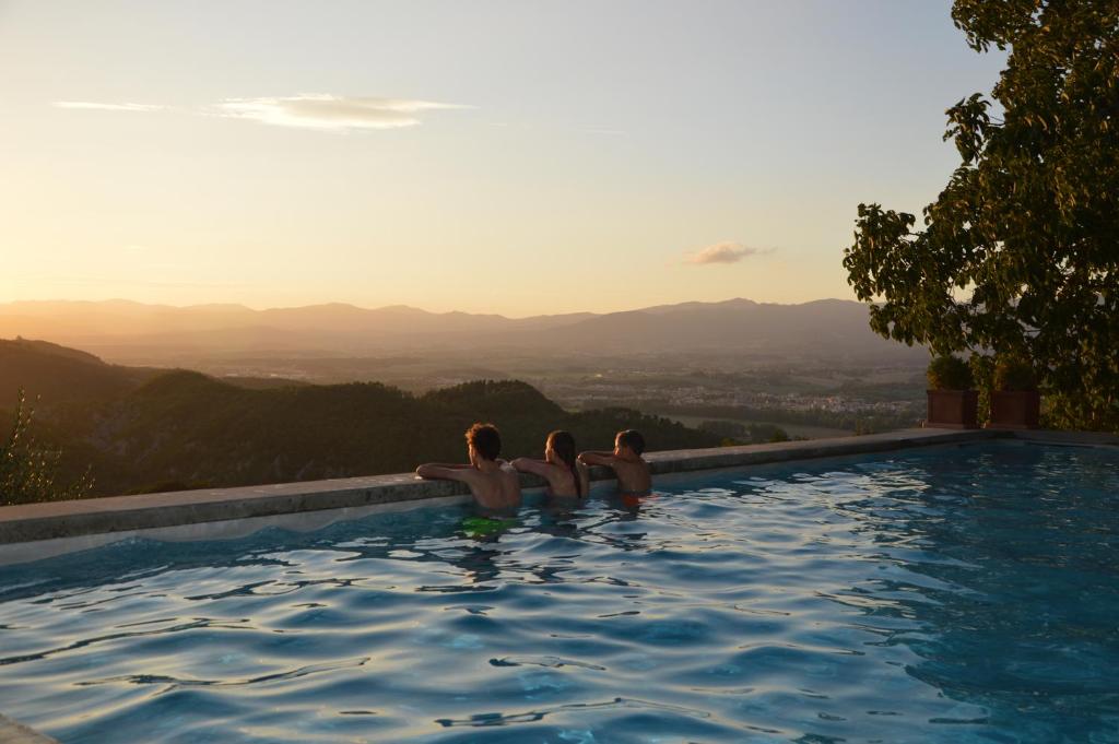 un grupo de tres personas sentadas en una piscina en Podere Capitignano en Borgo San Lorenzo