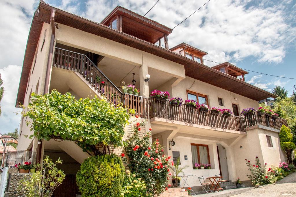 a house with flowers on the balconies of it at Guest House Kevser in Sarajevo