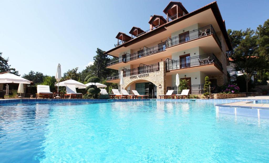 a large swimming pool in front of a hotel at Glikadi Hotel in Limenas