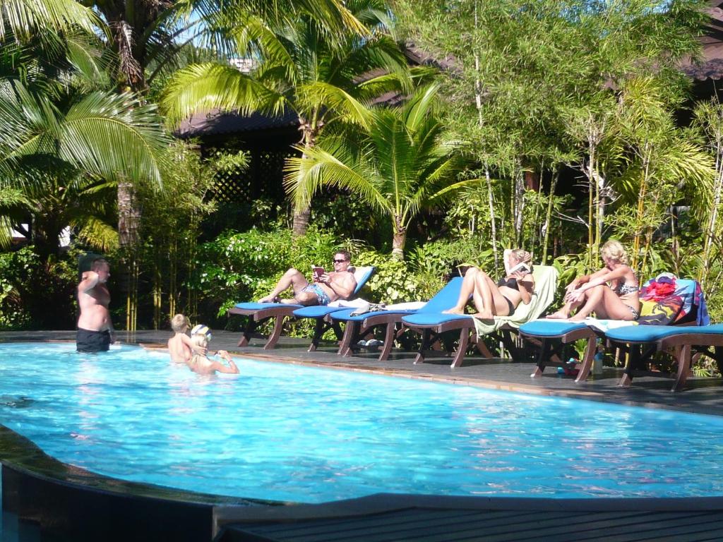 um grupo de pessoas sentadas numa piscina em Salad Hut em Salad Beach