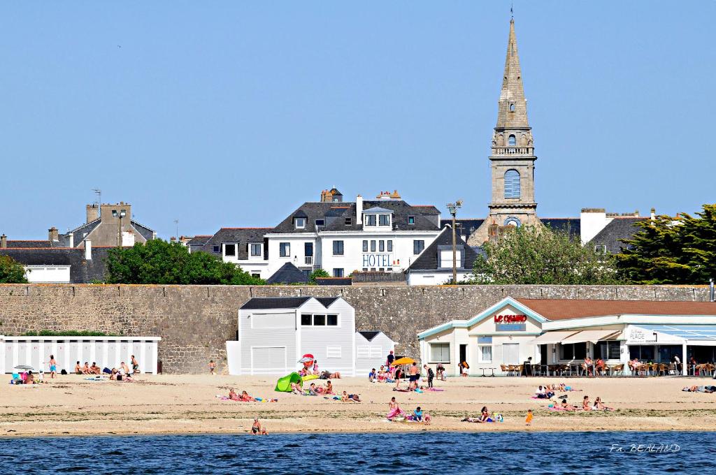 een groep mensen op een strand bij het water bij Hôtel Spa De La Citadelle Lorient in Port-Louis