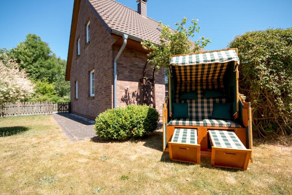 a chair sitting in a yard in front of a house at Haus Lotte in Garding