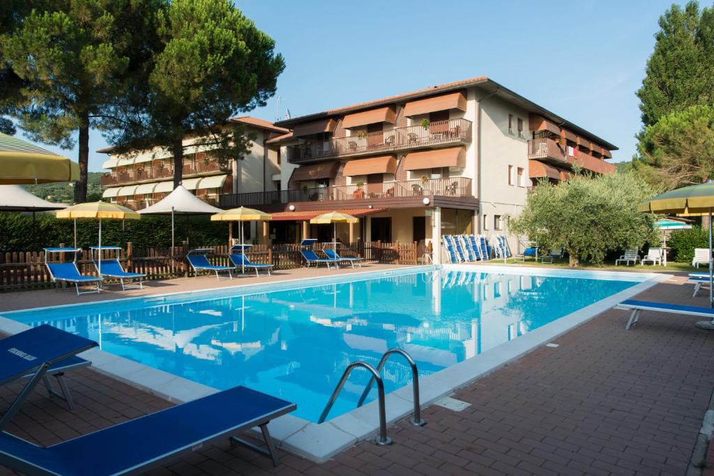 a swimming pool in front of a hotel at Hotel Torricella in Magione