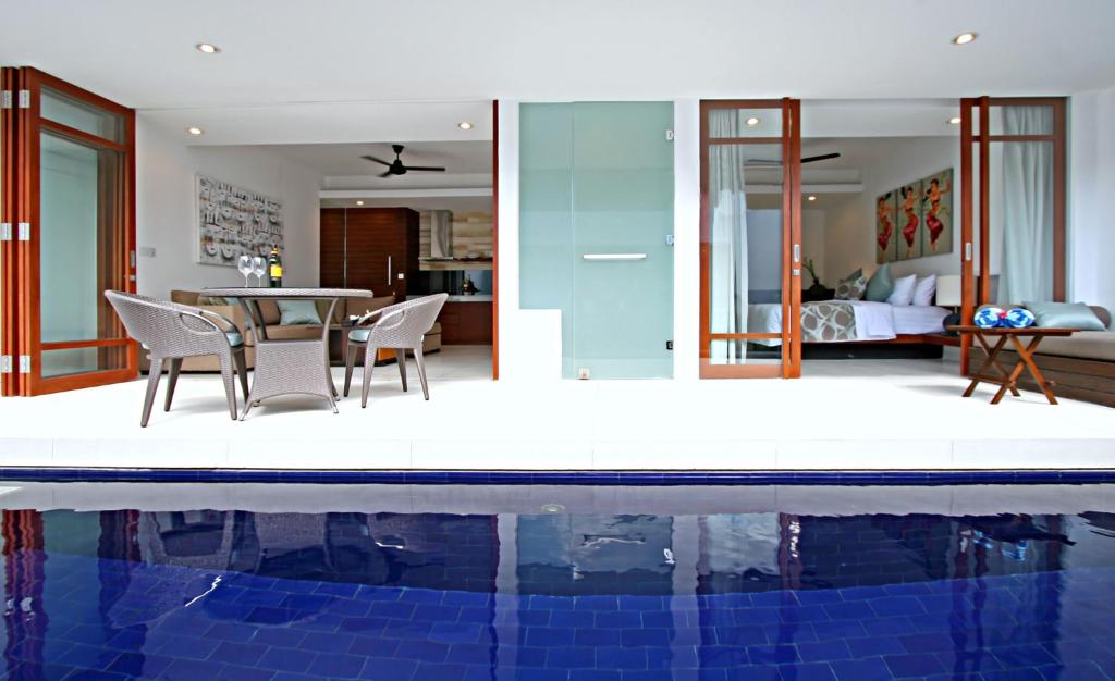 a villa with a pool and a bedroom at Smart Comfort Apartments in Sanur