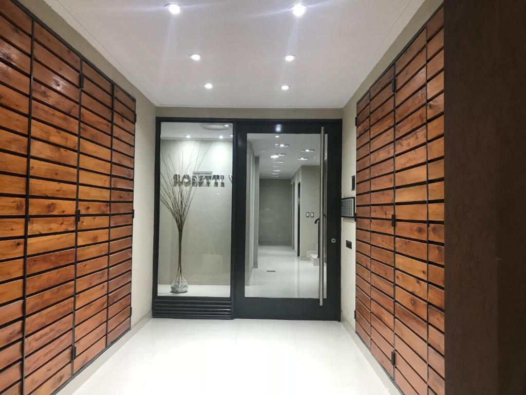 a hallway with a pivot door in a building at Wasi - El Palomar in El Palomar