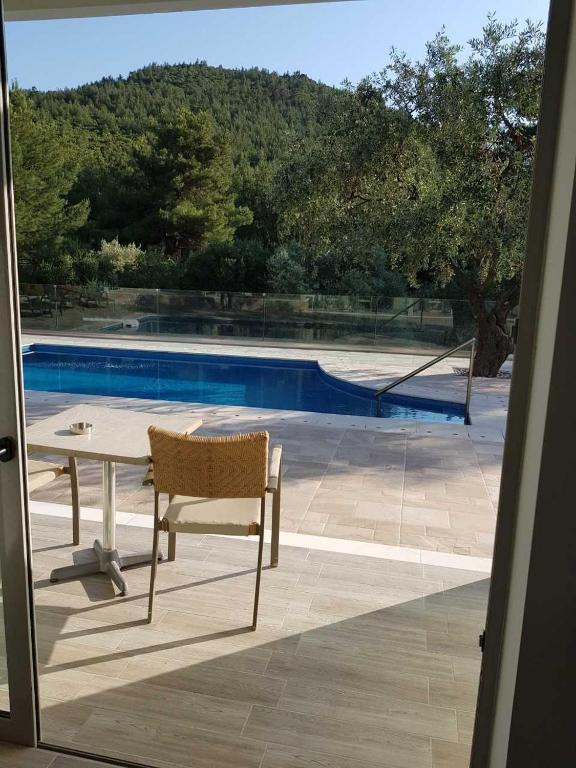 a table and a chair next to a swimming pool at Thassos Imperial Resort in Skala Rachoniou