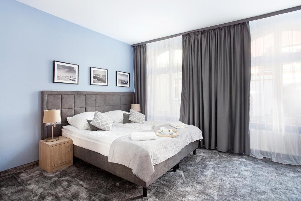 een slaapkamer met een groot bed en een groot raam bij Monte Carlo Apartments by OneApartments in Sopot