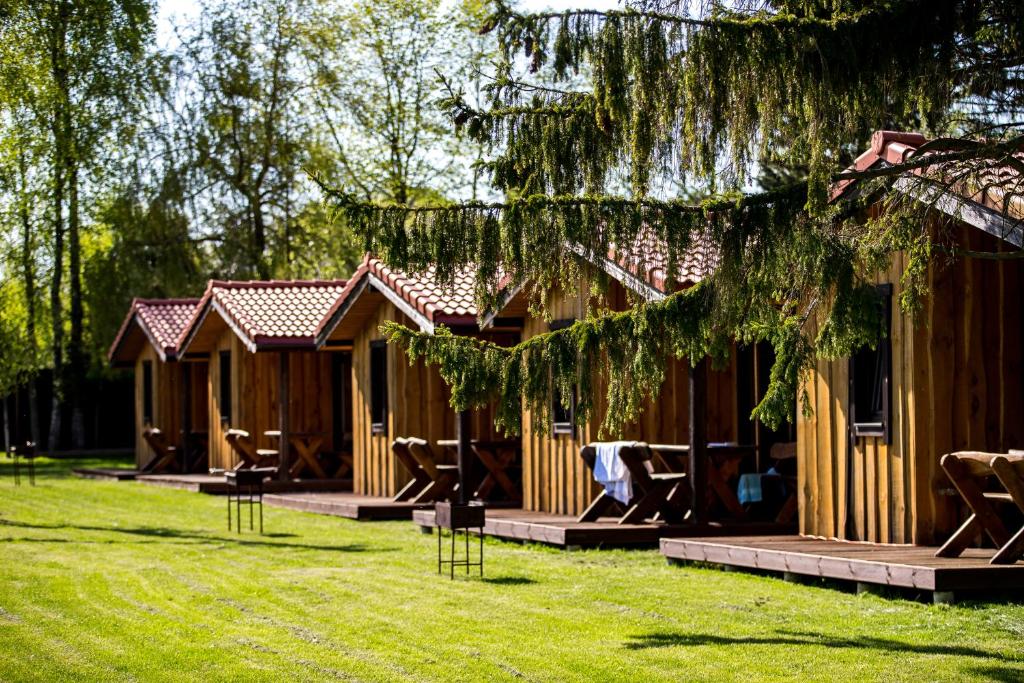 a wooden cabin with chairs in the grass at Fetingas in Šventoji