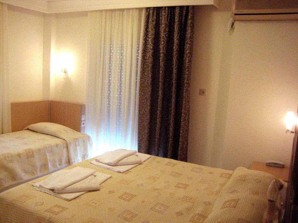a hotel room with two beds with towels on them at Hotel Avra in Perea
