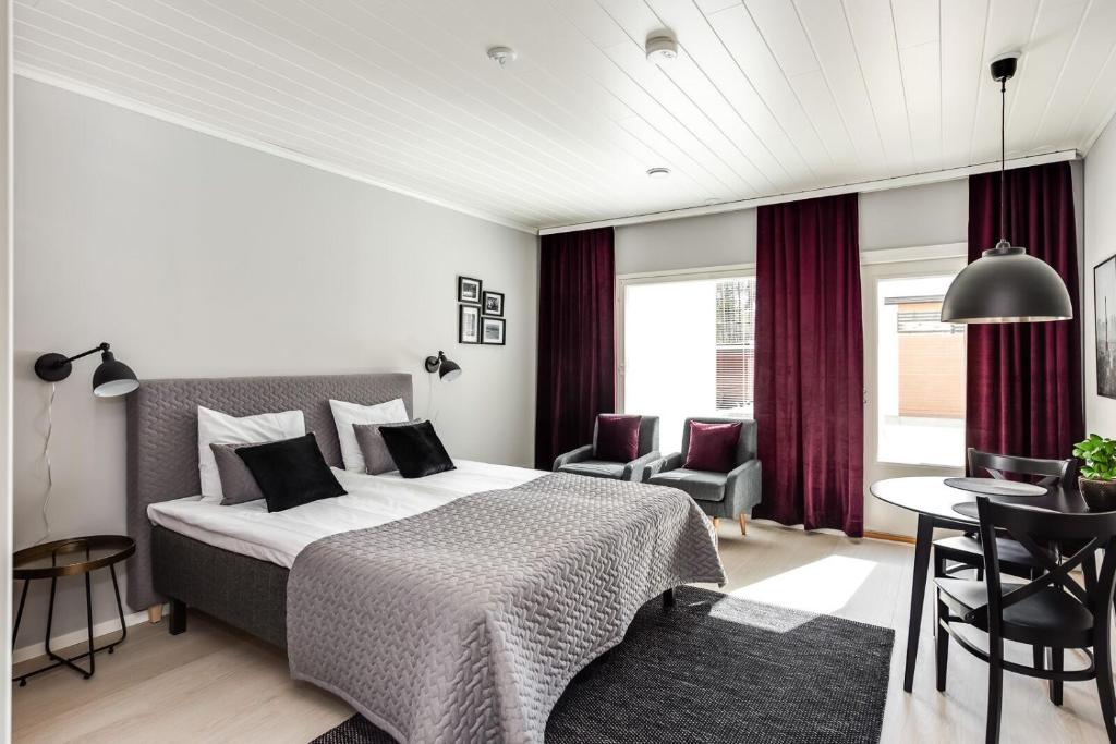 a bedroom with a bed and a table and chairs at Rantakallan Hongisto huoneistot in Kalajoki