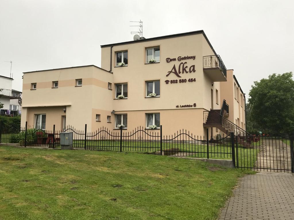 a building with a fence in front of a yard at Alka in Mielno