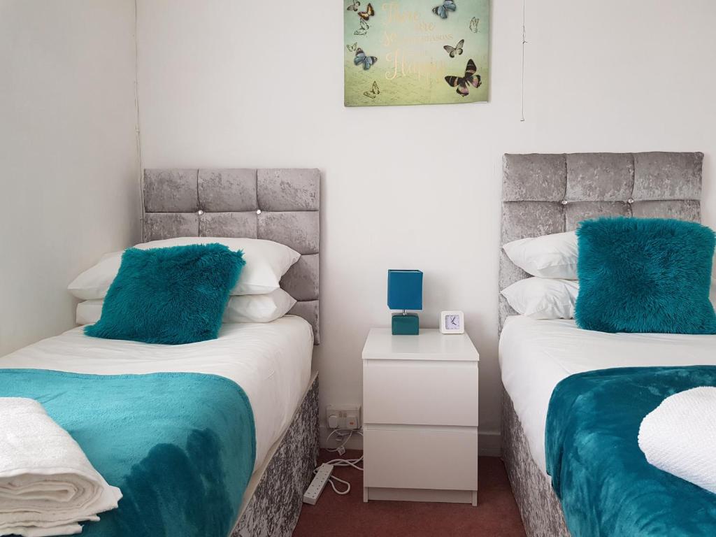 イプスウィッチにあるVetrelax Ipswich Newly Refurbished Houseのベッドルーム1室(青い枕付きのベッド2台付)