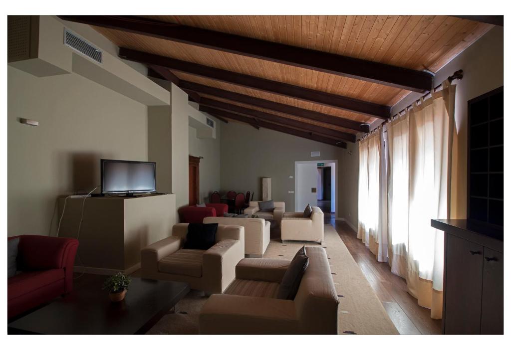 a living room with couches and a flat screen tv at Posada La Casona de Valbuena in Valbuena de Duero