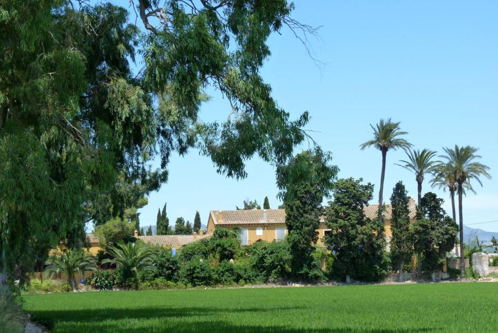 a house in the middle of a field with palm trees at Mas de Bernis 1888 in L'Aldea