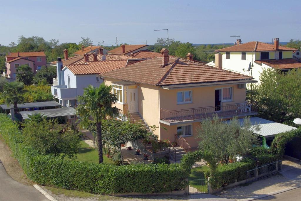 un groupe de maisons avec des arbres et des buissons dans l'établissement Apartments & Rooms BARBARA, à Umag