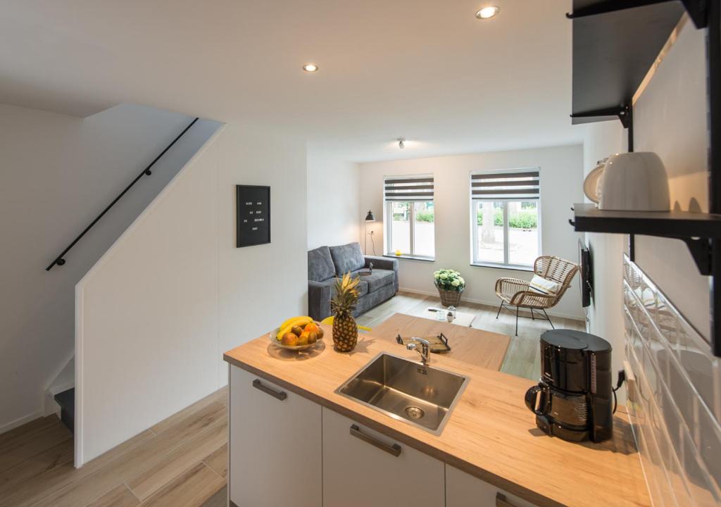Una cocina con fregadero y una sala de estar. en Holiday Home Zuidstraat 30B, en Westkapelle