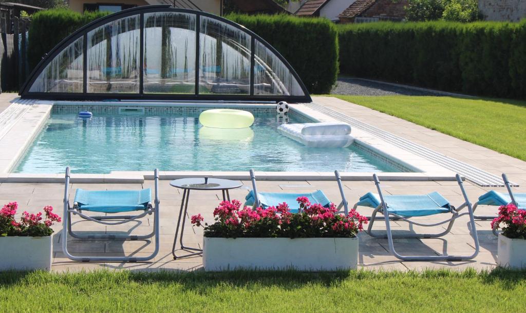 a pool with chairs and a table and a frisbee at Margaret Apartment in Balatonkeresztúr