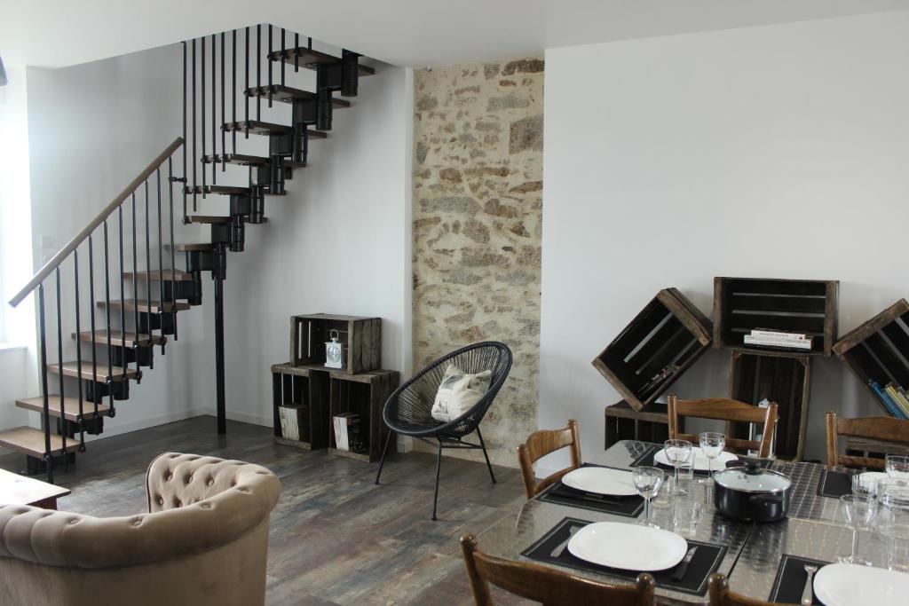 a living room with a table and a staircase at A chacun son nid in Les Épesses