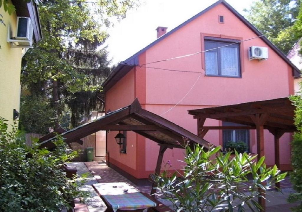 ハイドゥソボスローにあるMuskátli Apartman 2.のピンクと赤の家(パティオ付)