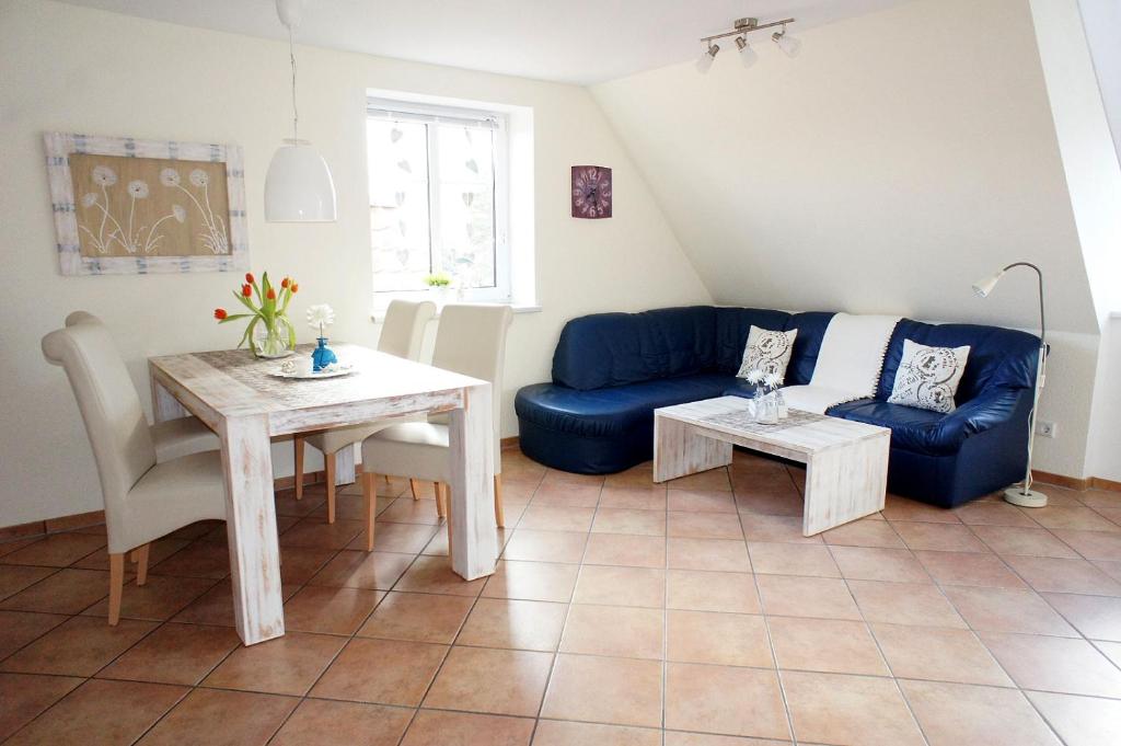 a living room with a blue couch and a table at Haus Wyden in Utersum